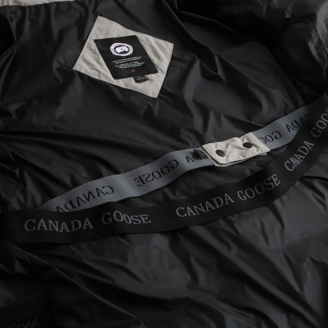 P1010 [Exclusive supply] Canada Goose Black Label Badge Hooded Down Jacket (Khaki) The high-quality filling is made of 90 national standard high-quality white duck down, selected high-loft velvet, weighing 240g, light and warm, with excellent temperature locking performance and good resilience. The fabric is woven with 400T high-count yarn. After special water-repellent treatment, the surface forms a lotus leaf effect - raindrops will slide down like beads, and snow particles will fall off when touched. The tear resistance reaches 200N (approximately 20kg load-bearing), the light gray matte texture breaks the stereotype of "outdoor clothing = hardcore", and the soft luster presents a high-end matte effect under urban neon lights, seamlessly switching scenes from ski resorts to CBD office buildings. The ribbon is woven with polyester as the base, and the brand letters are decorated on the ribbon through high-precision computer embroidery. The edges of the pattern are clear, the stitches are fine and even, and multiple layers of embroidery thread are stacked to enhance the three-dimensional effect. Precision thread reinforcement prevents linting and ensures the fluffy and resilient elasticity lasts as new. The embedded cuffs are three-dimensionally woven to form a "wavy" elastic structure, which forms natural folds when fitting the wrist, increasing the contact area with the skin, thus improving the windproof effect. At the same time, micro-velvet treatment is added to the inside of the cuffs, which feels like a second layer of skin and avoids friction on the skin from metal zippers or hard fabrics. Size:S-M-L-XL